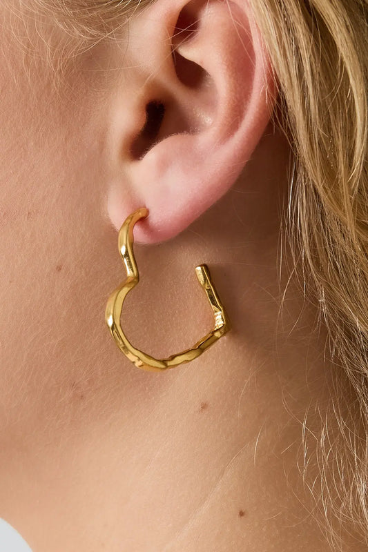 Grote hartvormige gouden oorbellen met een strak en elegant design, ideaal voor dagelijks gebruik of als cadeau.