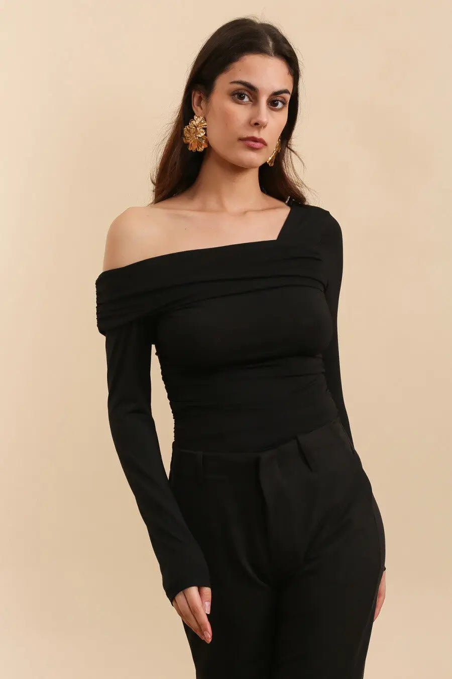 Aanfoto zwarte asymmetrische body met een lange mouw en blote schouder. Aansluitende pasvorm van stretchstof. Perfect voor iets casuals of feestelijk.
