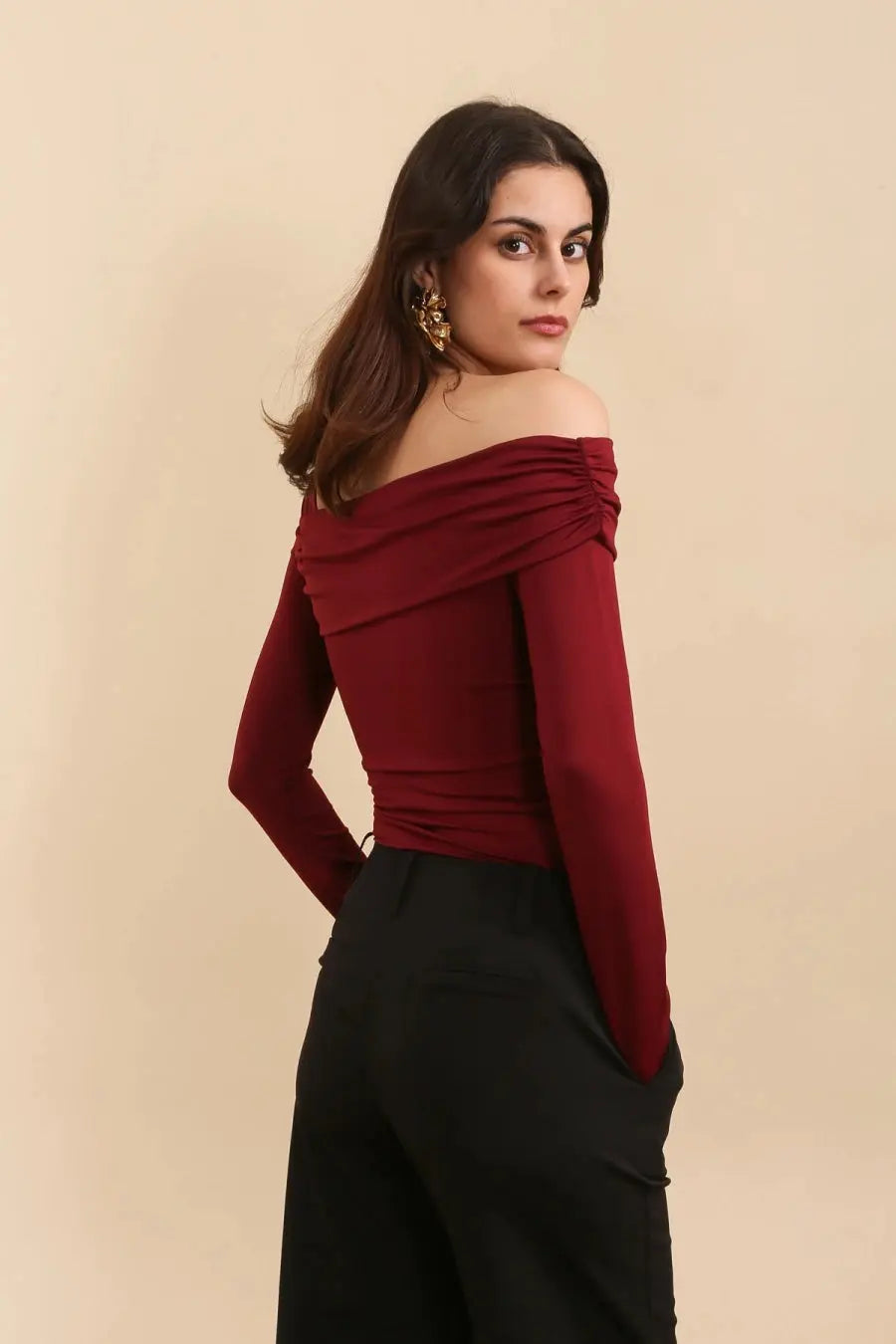 Achterkant bordeaux asymmetrische body met een lange mouw en blote schouder. Aansluitende pasvorm van stretchstof. Perfect voor iets casuals of feestelijk.